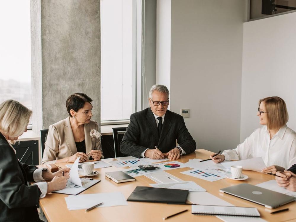 Auditors and accountants reviewing financial statements and charts at a table